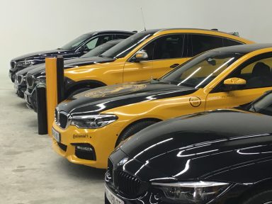Total covering adhésif Continental Série de voitures BMW de différentes couleurs alignées dans un garage.